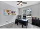 This office space features a ceiling fan, a large window overlooking the outdoors, and three colorful pieces of wall art at 201 Vinadio Blvd, Nokomis, FL 34275