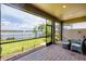 This patio features brick flooring, a view of the lake with a fountain, outdoor furniture, and a screened-in enclosure at 201 Vinadio Blvd, Nokomis, FL 34275