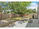Spacious backyard with a wooden fence, patio area, and shade from mature trees at 2218 Woodmere Rd, Venice, FL 34293