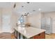 Kitchen boasts an island with seating, complemented by natural light and stainless steel refrigerator at 2218 Woodmere Rd, Venice, FL 34293