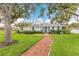 Charming single-story home with a brick walkway and a well-manicured lawn at 2401 Riverview Blvd, Bradenton, FL 34205