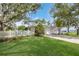 Quaint home showcasing a lush front yard with a white picket fence, mature trees, and a well-maintained lawn at 2401 Riverview Blvd, Bradenton, FL 34205