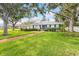 Charming single-story home with a manicured lawn, mature trees, white trim, and a welcoming red brick walkway at 2401 Riverview Blvd, Bradenton, FL 34205