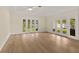 Light-filled living area with wood floors and French doors offering outdoor views of a pool at 2401 Riverview Blvd, Bradenton, FL 34205