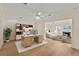 Bright office with wooden desk, shelving unit, and a view into the living room with fireplace and coastal view at 2401 Riverview Blvd, Bradenton, FL 34205