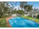 A sparkling in-ground pool with brick coping and lush landscaping in the backyard at 2401 Riverview Blvd, Bradenton, FL 34205