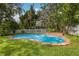 A refreshing pool with brick trim surrounded by a spacious green lawn at 2401 Riverview Blvd, Bradenton, FL 34205