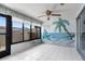 Bright and airy enclosed lanai with tile flooring and decorative beach themed wall mural at 2915 29Th W Ave, Bradenton, FL 34205