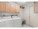 Laundry room with washer, dryer, storage cabinets, and a storage rack at 2915 29Th W Ave, Bradenton, FL 34205