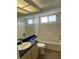 Bathroom with a tub, vanity, commode, and a bright window providing natural light to the room at 3032 Heron Lake Ct # 7B, Venice, FL 34293