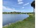 Beautiful lake view showcasing the expansive water, lush trees and a scenic grassy shoreline at 3032 Heron Lake Ct # 7B, Venice, FL 34293