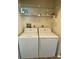 Laundry area featuring a stacked washer and dryer, with shelving providing extra storage at 3032 Heron Lake Ct # 7B, Venice, FL 34293