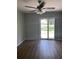 Living room with wood floors, a ceiling fan, and sliding glass doors to let in plenty of natural light at 3032 Heron Lake Ct # 7B, Venice, FL 34293