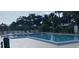 Community pool featuring clear blue water, surrounding lounge chairs, and shaded areas at 3032 Heron Lake Ct # 7B, Venice, FL 34293