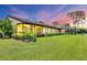Expansive backyard featuring a screened-in lanai, lush green grass, and meticulously maintained landscaping at 3617 Yellow Pine Ct # 144, Sarasota, FL 34238