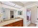 Bright bathroom with granite countertop, wood cabinet, large mirror, and a shower with pink tile at 3617 Yellow Pine Ct # 144, Sarasota, FL 34238