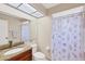 Bright bathroom featuring a granite vanity top and a shower with decorative seashell curtains at 3617 Yellow Pine Ct # 144, Sarasota, FL 34238
