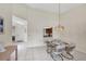 Elegant dining area with a glass table, stylish chairs, and a view to the kitchen at 3617 Yellow Pine Ct # 144, Sarasota, FL 34238