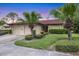 Charming single-story home featuring a well-manicured lawn, mature palm trees, and a two-car garage at 3617 Yellow Pine Ct # 144, Sarasota, FL 34238