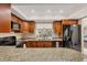 Well-lit kitchen with granite countertops, wood cabinets, and modern black appliances at 3617 Yellow Pine Ct # 144, Sarasota, FL 34238