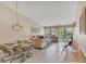 Open-concept living and dining area with tile floors, a glass table and comfortable sofas at 3617 Yellow Pine Ct # 144, Sarasota, FL 34238