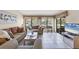 Living room with tile floors, large windows, and neutral-toned sofas, well-lit at 3617 Yellow Pine Ct # 144, Sarasota, FL 34238