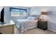 Comfortable bedroom with soft blue walls, window, and stylish nightstand at 3721 Somerville Dr # 1513, Sarasota, FL 34232