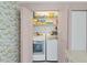 Laundry area with floral wallpaper, a washer and dryer, and extra storage space at 3810 75Th W St # 128, Bradenton, FL 34209