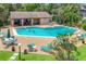 Relaxing community pool with sun loungers and chairs, surrounded by lush trees and landscaping at 3810 75Th W St # 128, Bradenton, FL 34209