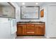 Bathroom featuring double sinks, wooden cabinets, a large mirror and a glass-enclosed shower at 3915 Meadow Creek Dr, Sarasota, FL 34233