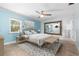 Comfortable bedroom with blue walls, ceiling fan, tile floor, and a large mirror that enhances the room's spacious feel at 3915 Meadow Creek Dr, Sarasota, FL 34233