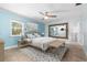 Light-filled bedroom featuring tile floors, neutral decor, ceiling fan, and a spacious walk-in closet at 3915 Meadow Creek Dr, Sarasota, FL 34233