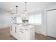 Modern kitchen island with white cabinets, quartz countertops and dining area at 3915 Meadow Creek Dr, Sarasota, FL 34233