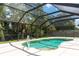 Screened-in pool area featuring a refreshing pool, palm trees and lush green foliage at 3915 Meadow Creek Dr, Sarasota, FL 34233
