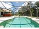 Screened-in pool area featuring a refreshing pool, palm trees and blue skies at 3915 Meadow Creek Dr, Sarasota, FL 34233