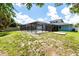 Backyard view of screened pool and home with blue exterior, perfect for outdoor relaxation and entertainment at 3915 Meadow Creek Dr, Sarasota, FL 34233