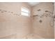 Beautifully tiled shower with rainfall showerhead, hand-held sprayer, and a built-in niche for storage at 3915 Meadow Creek Dr, Sarasota, FL 34233