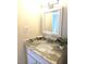 Close-up of a vanity with marble countertop, stylish faucet, and decorative mirror at 4001 Beneva Rd # 319, Sarasota, FL 34233