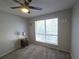 A simple bedroom features a window with blinds, carpet flooring, and neutral-painted walls at 4001 Beneva Rd # 319, Sarasota, FL 34233