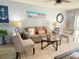 A cozy living room featuring a neutral sofa, armchairs, coastal decor, and a ceiling fan at 4001 Beneva Rd # 319, Sarasota, FL 34233