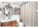 Bathroom with octagon mirror, white vanity top, wood cabinets and shower with geometric pattern curtain at 4440 Fairways Blvd # 310, Bradenton, FL 34209