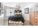 Bedroom featuring black metal bed frame, ceiling fan, wood floors, dresser and a window bringing in natural light at 4440 Fairways Blvd # 310, Bradenton, FL 34209