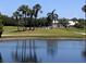 Picturesque golf course with palm trees reflected in a serene pond, showcasing the beautiful waterfront property at 4440 Fairways Blvd # 310, Bradenton, FL 34209