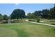Scenic golf course view with lush green fairways, a tranquil pond, and mature trees under a clear blue sky at 4440 Fairways Blvd # 310, Bradenton, FL 34209