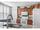 Well-lit kitchen with granite countertops, white appliances, and a view of shuttered windows at 4440 Fairways Blvd # 310, Bradenton, FL 34209