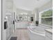 Bright bathroom with white tiled floors, soaking tub, and glass shower enclosure at 4531 Useppa Dr, Bradenton, FL 34203