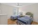 Bright guest bedroom is furnished with a pair of twin beds and a ceiling fan at 4531 Useppa Dr, Bradenton, FL 34203