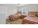 Charming bedroom features a window, twin beds, and wood-look flooring at 4531 Useppa Dr, Bradenton, FL 34203