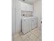 Laundry area featuring white appliances, storage cabinets, and tiled floor at 4531 Useppa Dr, Bradenton, FL 34203