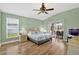 The main bedroom features wood floors, a ceiling fan, a sliding glass door to the patio, and ample natural light at 4531 Useppa Dr, Bradenton, FL 34203